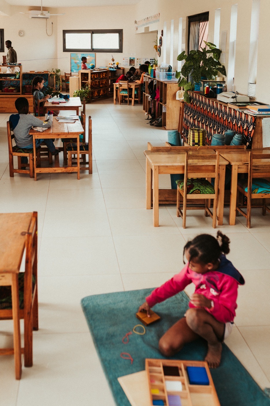 Enfant assis sur un tapis avec son matériel